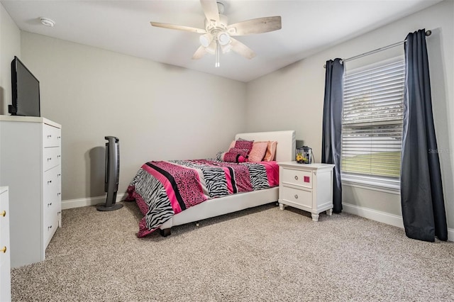 carpeted bedroom with ceiling fan and baseboards