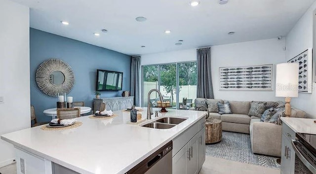 kitchen featuring open floor plan, dishwasher, light countertops, range with electric stovetop, and a sink