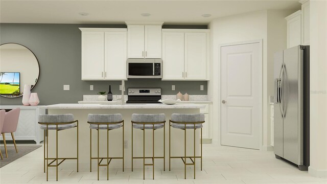 kitchen featuring stainless steel appliances, a breakfast bar area, and white cabinets