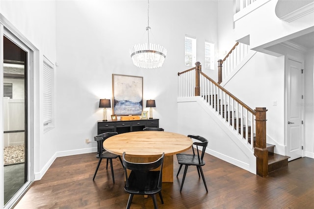 dining area with a notable chandelier, dark wood finished floors, stairway, baseboards, and a towering ceiling