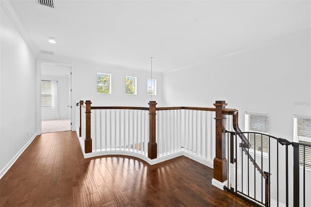 hallway featuring visible vents, crown molding, baseboards, an upstairs landing, and wood finished floors