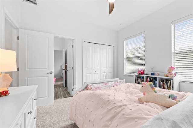 bedroom with visible vents, multiple windows, carpet, and a closet