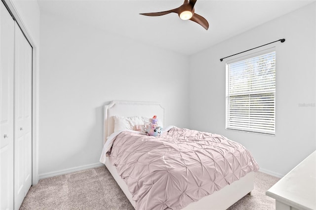 carpeted bedroom with a ceiling fan, baseboards, and a closet