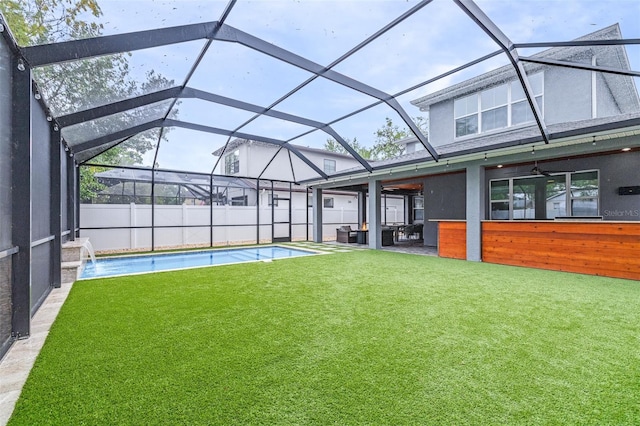 rear view of property featuring glass enclosure, a patio, a fenced in pool, fence, and a lawn