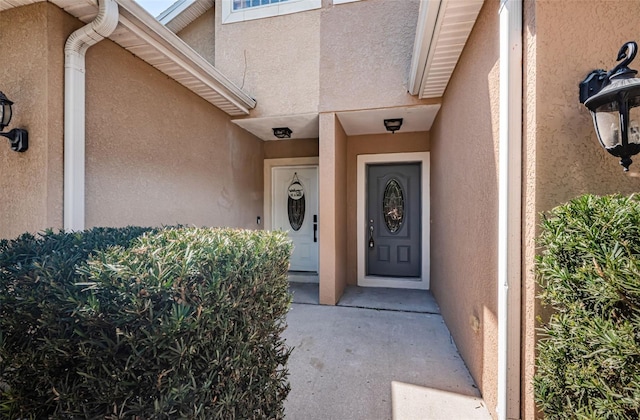 property entrance with stucco siding