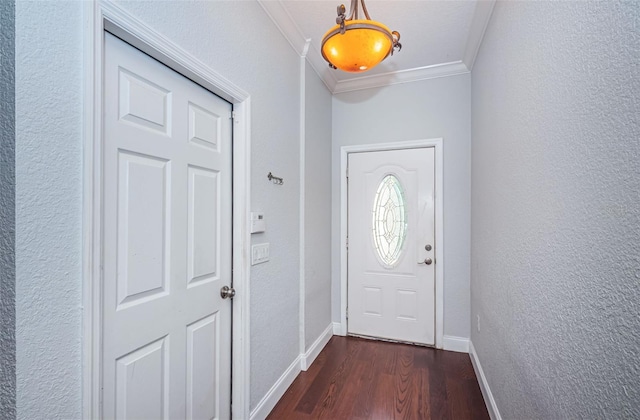 entryway with dark wood-style floors, baseboards, a textured wall, and ornamental molding