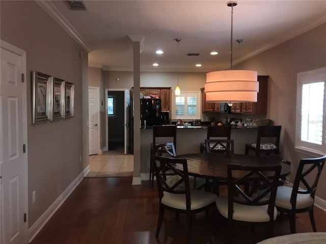 dining space featuring a wealth of natural light, visible vents, and ornamental molding