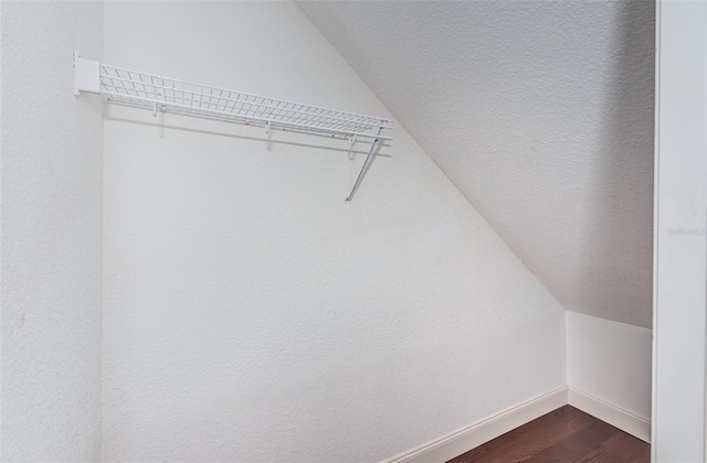 walk in closet featuring vaulted ceiling and dark wood-style floors