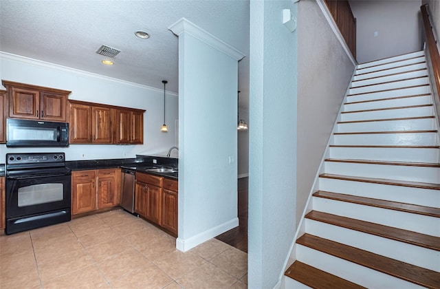 kitchen with dark countertops, visible vents, crown molding, brown cabinets, and black appliances