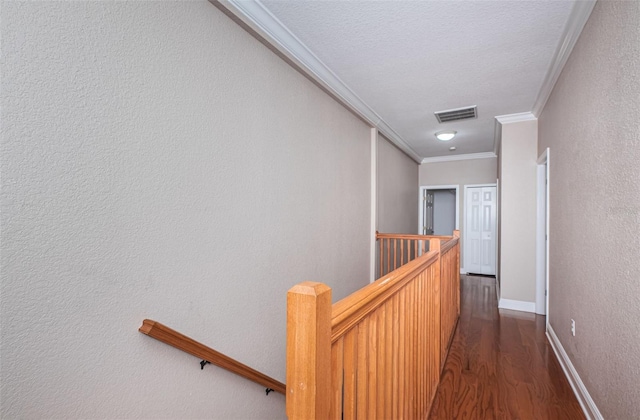 hallway with visible vents, an upstairs landing, dark wood-style floors, crown molding, and a textured wall