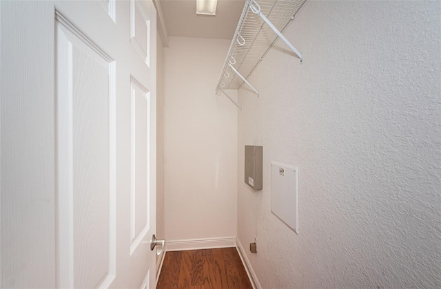 clothes washing area featuring laundry area, wood finished floors, baseboards, and electric dryer hookup