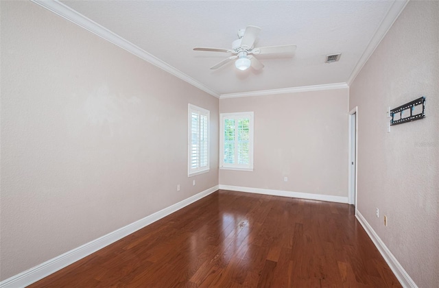 empty room featuring visible vents, crown molding, ceiling fan, baseboards, and wood finished floors