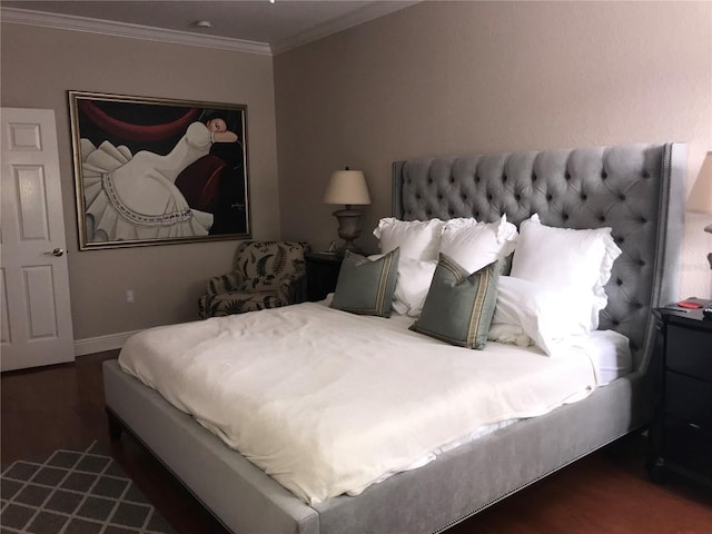 bedroom with crown molding, wood finished floors, and baseboards