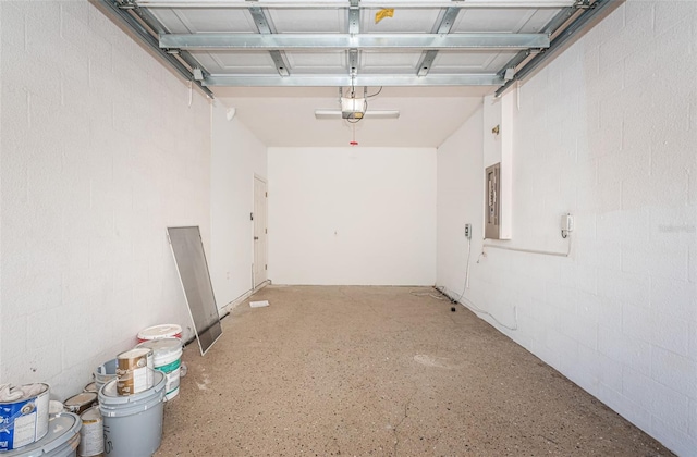 garage with electric panel, a garage door opener, and concrete block wall