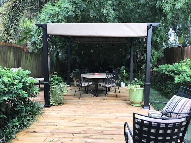 deck with outdoor dining area and fence