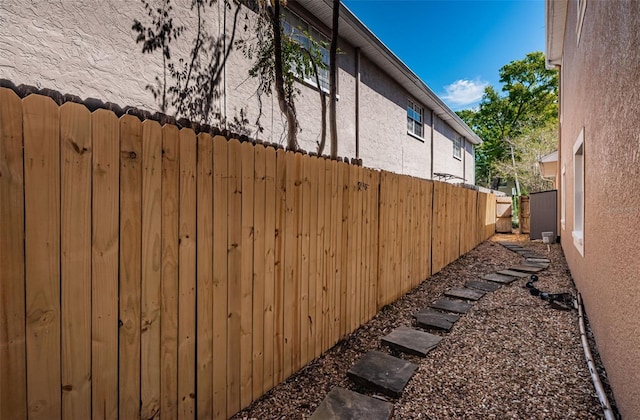 view of home's exterior with stucco siding and fence