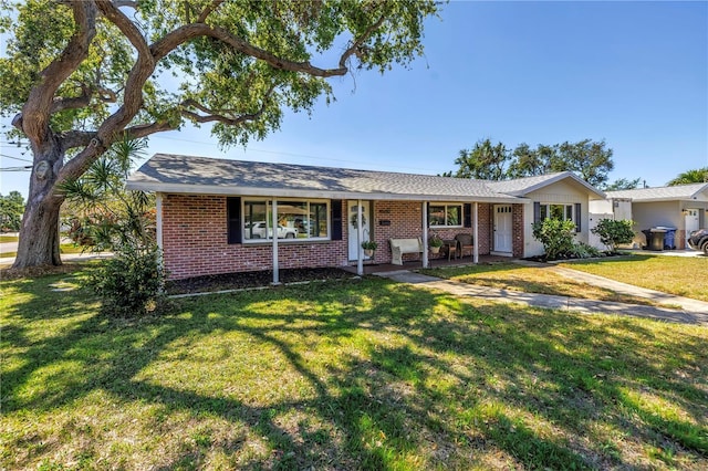 ranch-style home featuring brick siding, a porch, and a front lawn