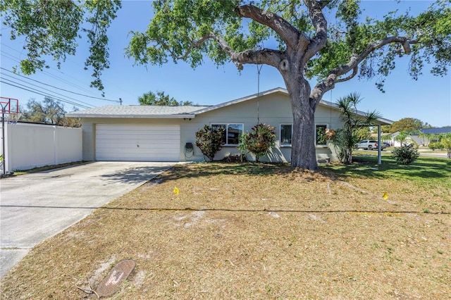 ranch-style house with driveway, an attached garage, a front lawn, and fence