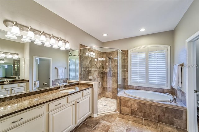 full bathroom featuring vanity, a bath, a shower stall, and tile patterned flooring