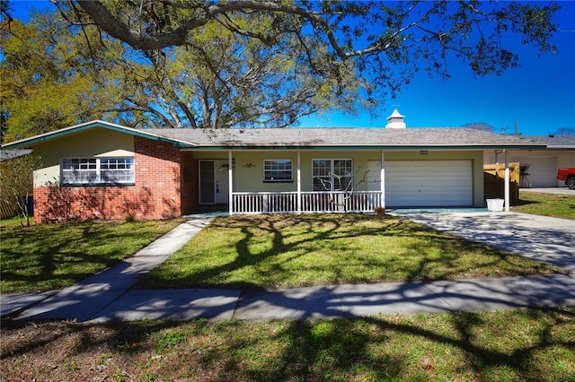 single story home with a front yard, brick siding, a garage, and driveway