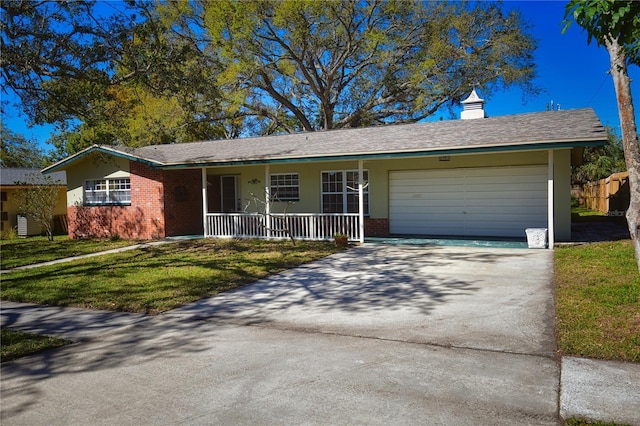 ranch-style house featuring driveway, a front lawn, covered porch, an attached garage, and brick siding