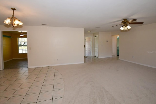 spare room with light carpet, visible vents, ceiling fan with notable chandelier, and baseboards