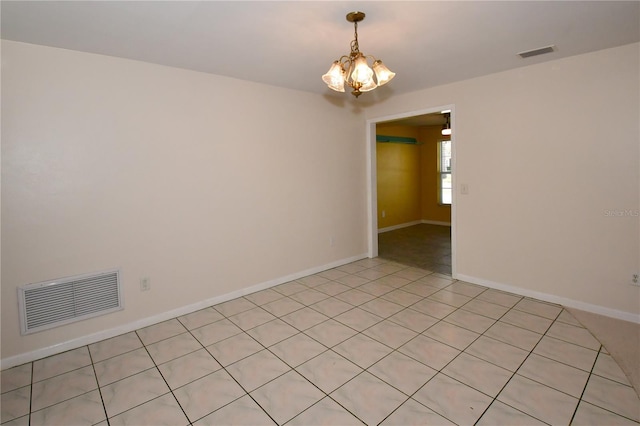 spare room with visible vents, baseboards, and a chandelier