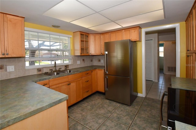 kitchen with electric range, dark tile patterned floors, a sink, dark countertops, and freestanding refrigerator