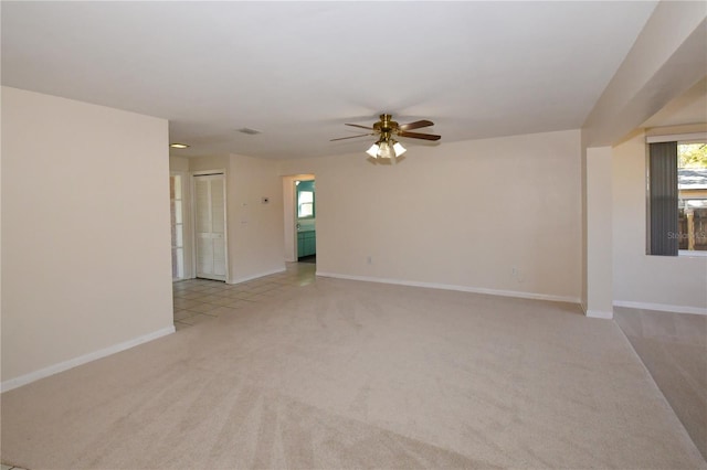 unfurnished room featuring carpet flooring, visible vents, baseboards, and ceiling fan