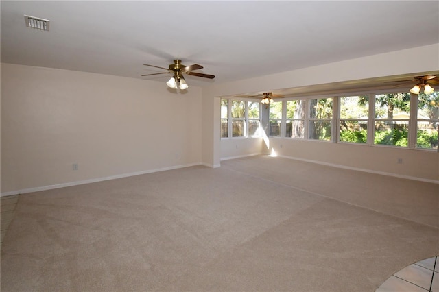 spare room with light carpet, visible vents, baseboards, and ceiling fan