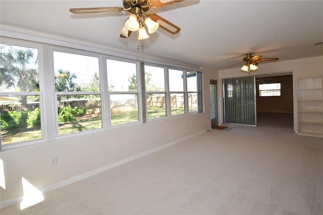 unfurnished sunroom with visible vents and ceiling fan