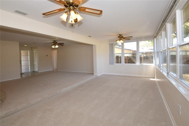 interior space featuring visible vents, light carpet, baseboards, and a ceiling fan