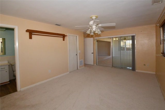 unfurnished bedroom featuring visible vents, light colored carpet, and baseboards