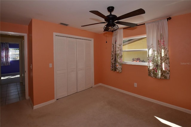 unfurnished bedroom with visible vents, baseboards, a closet, and carpet flooring