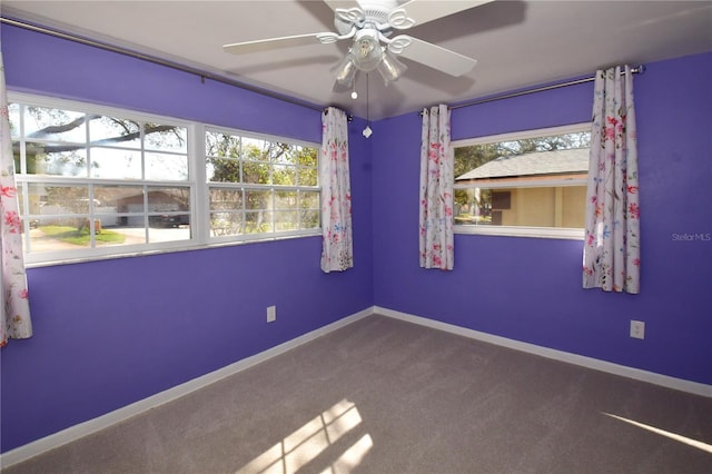 carpeted spare room featuring baseboards, plenty of natural light, and a ceiling fan