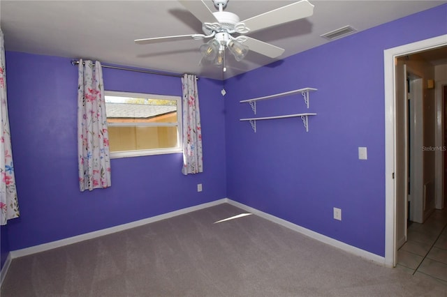 empty room featuring visible vents, baseboards, carpet, and a ceiling fan