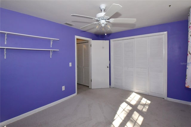 unfurnished bedroom featuring a ceiling fan, carpet, visible vents, baseboards, and a closet