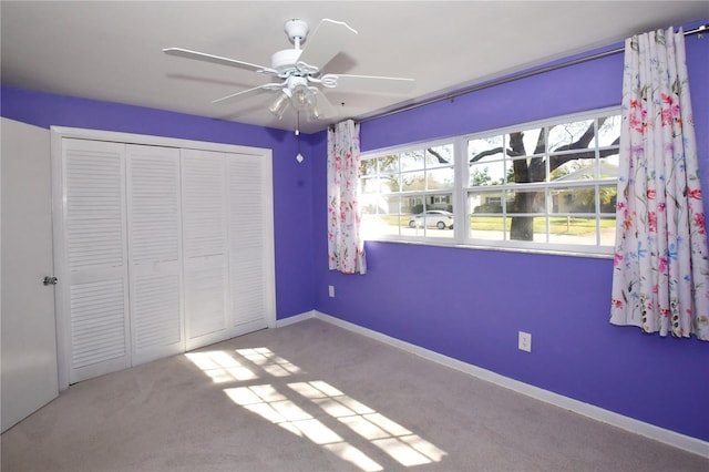 unfurnished bedroom featuring a closet, carpet flooring, ceiling fan, and baseboards