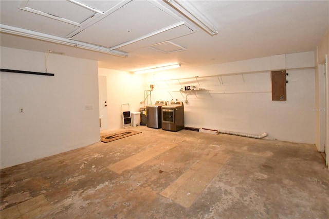 garage featuring electric panel and washing machine and clothes dryer