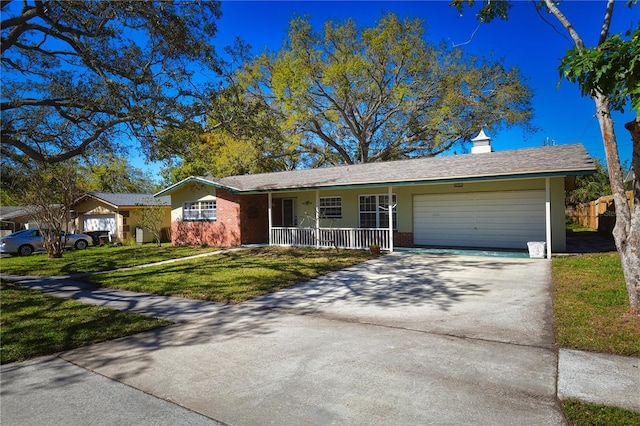 ranch-style house featuring a porch, a front lawn, concrete driveway, a garage, and brick siding