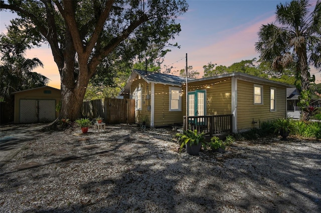 view of front of house with an outdoor structure and fence