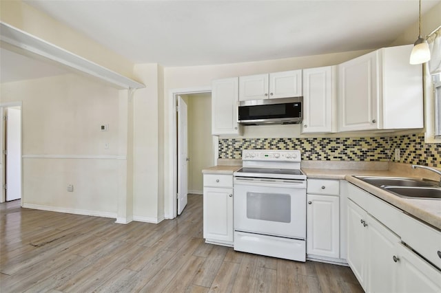 kitchen with electric range, backsplash, stainless steel microwave, and a sink