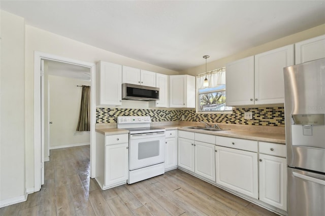 kitchen with light wood-style flooring, backsplash, stainless steel appliances, and light countertops