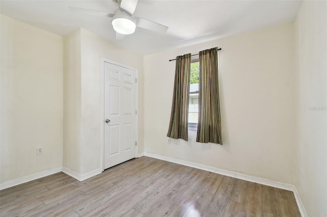 empty room with ceiling fan, baseboards, and wood finished floors