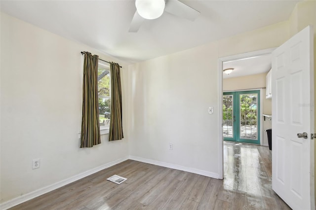 spare room with visible vents, ceiling fan, baseboards, french doors, and wood finished floors