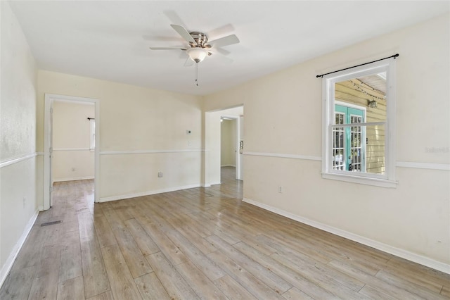 empty room with visible vents, baseboards, ceiling fan, and wood finished floors