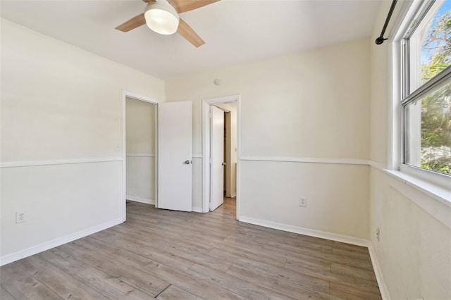 spare room with plenty of natural light, wood finished floors, and baseboards