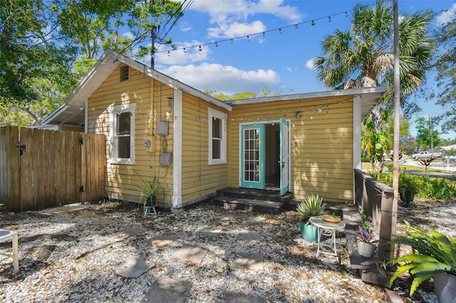 rear view of property with entry steps and fence