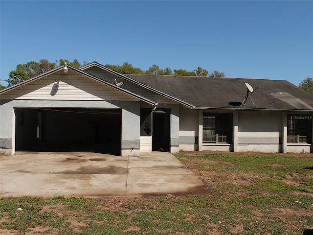 view of front of house with stucco siding, concrete driveway, and an attached garage