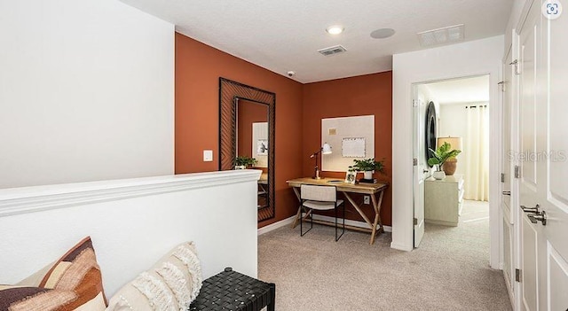 hall with light carpet, visible vents, and baseboards